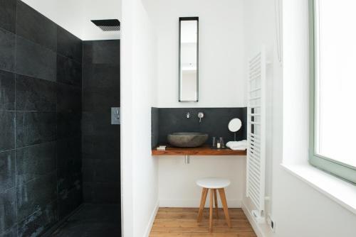 een badkamer met een wastafel en een aanrecht met een kruk bij Villa l'Accalmie in Wimereux