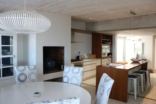 a kitchen with a white table and some chairs at Dune Ridge Main House in Paternoster