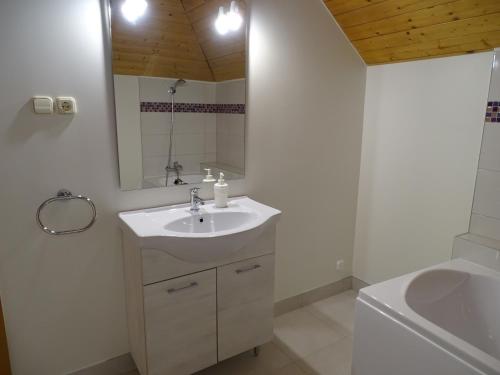 a bathroom with a sink and a mirror and a tub at Alabárdos Panzió és Apartmanház in Esztergom