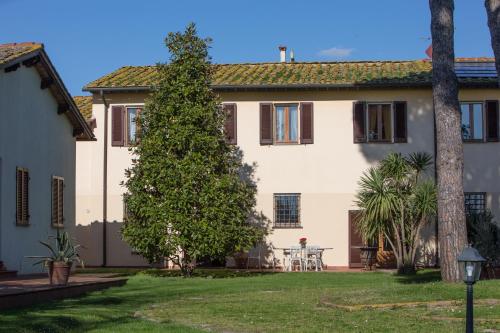 a large house with a tree in the yard at Podere Magnolia in Pisa
