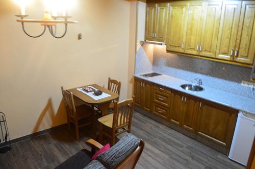 a kitchen with a table and a small kitchen with a table and chairs at Apartamento El Valle de Oscos in Santa Eulalia de Oscos