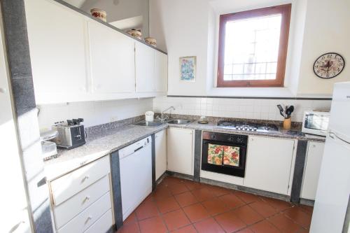 a kitchen with white cabinets and an oven at Podere Magnolia in Pisa