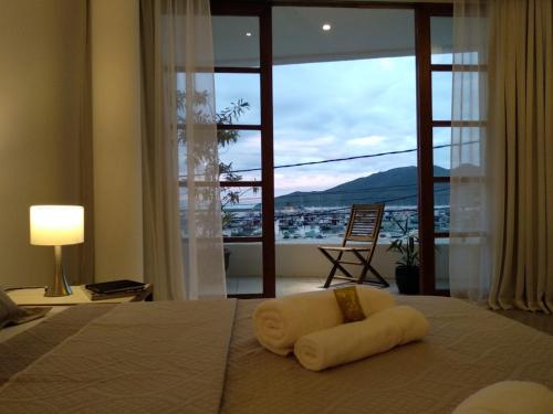 a hotel room with a bed with a large window at Orlanova Boutique Hotel in Arraial do Cabo