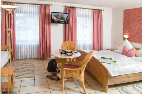 a bedroom with a bed and a table and chairs at Hotel-Restaurant Im Goldenen Grund in Körperich