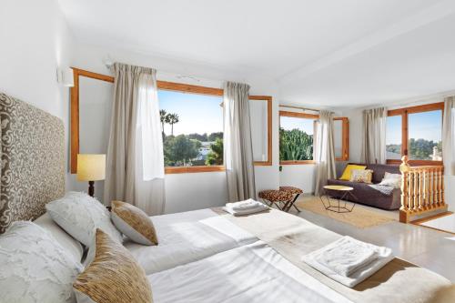 a white bedroom with a large bed and a couch at Casa del Capitán in Santa Ponsa