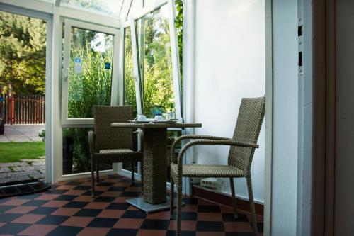 - une terrasse couverte avec des chaises et une table sur un sol en damier dans l'établissement Vila Josefina, à Prague