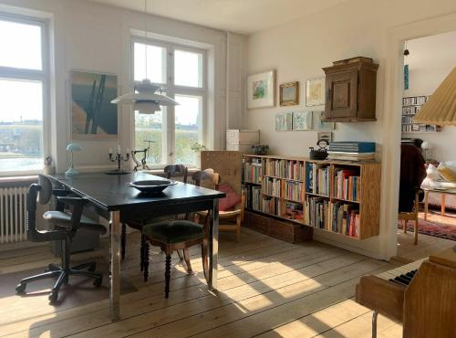 un soggiorno con tavolo e libreria di ApartmentInCopenhagen Apartment 1454 a Copenaghen