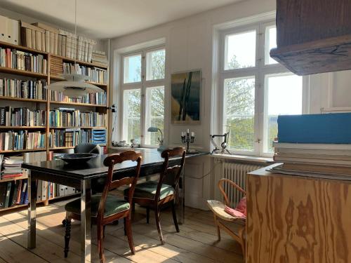 una habitación con mesa y sillas en una biblioteca en ApartmentInCopenhagen Apartment 1454 en Copenhague
