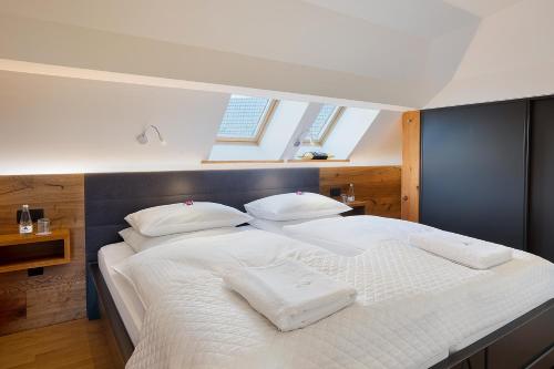 a bedroom with a large bed with white sheets and pillows at Apartment Wellness Essense in Bled