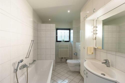 Un baño con bañera, inodoro y lavabo. en Lund36, en Husum