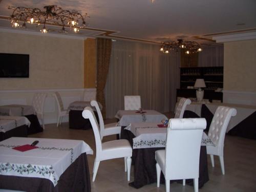a dining room with white tables and white chairs at Hotel Madonna Delle Grazie in Ceglie Messapica