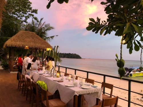 a dinner table on the beach at a resort at Phi Phi Villa Resort in Phi Phi Don