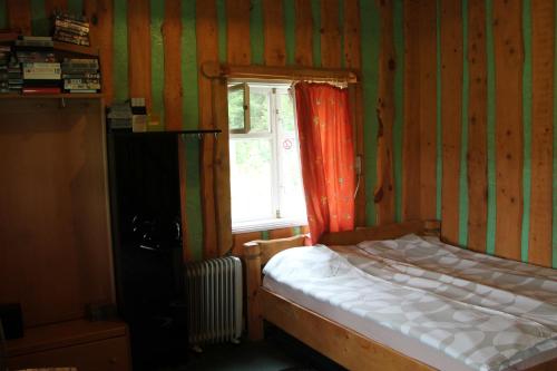 a small bedroom with a bed and a window at Zemaite truoba in Milašaičiai