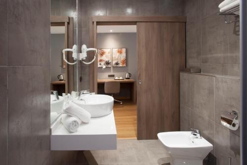 a bathroom with two sinks and a toilet at Hotel Colon Rambla in Santa Cruz de Tenerife