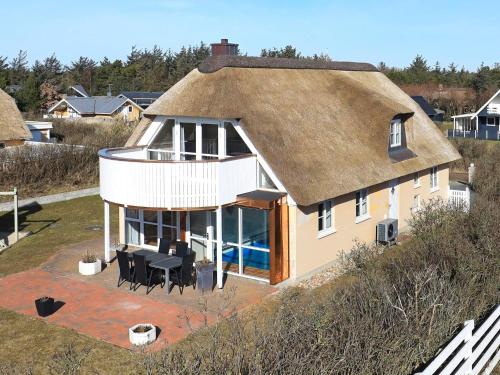 an aerial view of a house with a thatched roof at 8 person holiday home in Bl vand in Blåvand