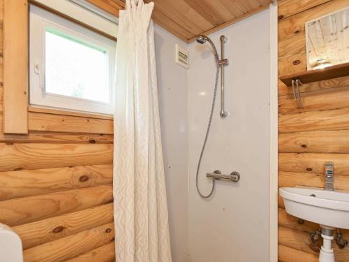 y baño con ducha y lavamanos. en Holiday Home Torpet VI, en Hovborg