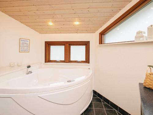 eine weiße Badewanne im Bad mit Fenster in der Unterkunft 8 person holiday home in L kken in Lønstrup