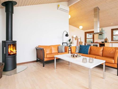 ein Wohnzimmer mit einem Sofa und einem Kamin in der Unterkunft 8 person holiday home in L kken in Lønstrup