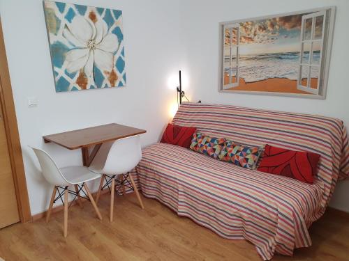 a bedroom with a bed and a desk and a table at Rico Apartaments Parador in Nerja