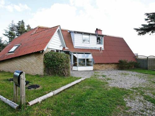 uma casa com um telhado vermelho e um quintal em 7 person holiday home in Lemvig em Trans