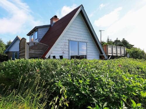 a house with a gambrel roof on top of a hill at 7 person holiday home in Lemvig in Trans