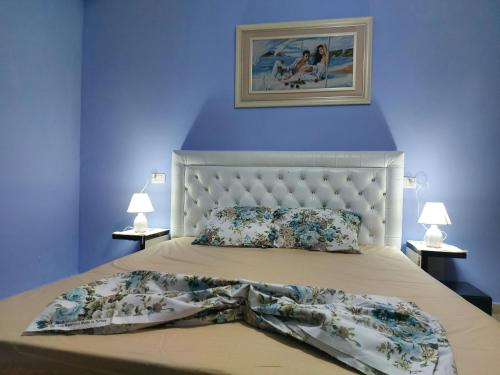 um quarto com uma cama com uma parede azul em Bral Apartment 3 em Durrës
