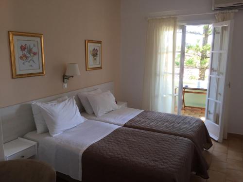 a hotel room with a bed and a window at Villa Tina Country Beach Apartments in Acharavi