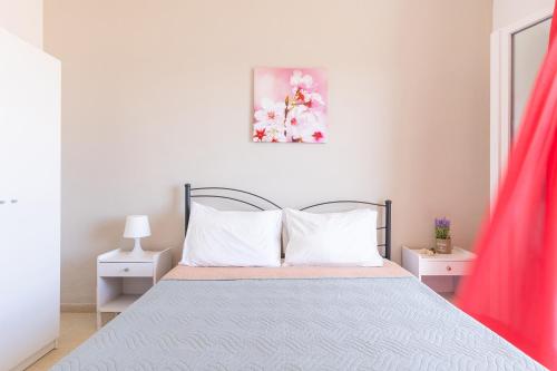 a white bedroom with a bed with white pillows at Katerina Horizon Apartments by Konnect - 1,8km from Ipsos beach in Ýpsos