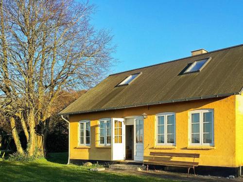 a yellow house with a bench in front of it at 6 person holiday home in Aabenraa in Aabenraa