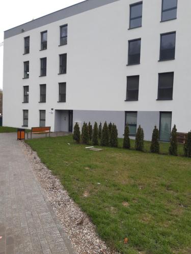 - un bâtiment blanc avec un parc en face dans l'établissement Apartament Nadmorskie Tarasy z widokiem na morze, à Gdynia