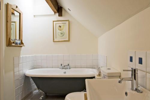 a bathroom with a tub and a toilet and a sink at Nether Farm Barns in Ashbourne
