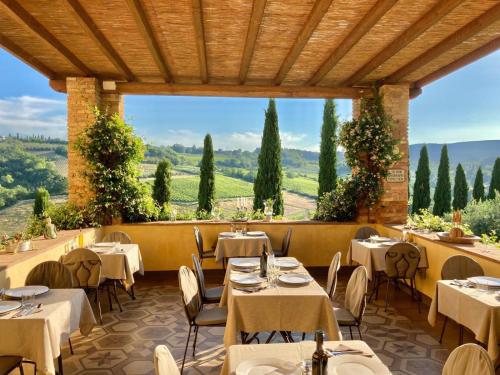 a restaurant with tables and chairs and a view of the countryside at Agriturismo Il Segreto di Pietrafitta in San Gimignano