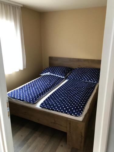 uma cama com lençóis de bolinhas azuis num quarto em Dunasor1 Apartman em Dömsöd