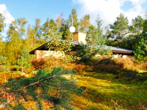 a house on a hill with a tree in the foreground at 6 person holiday home in Nex in Spidsegård