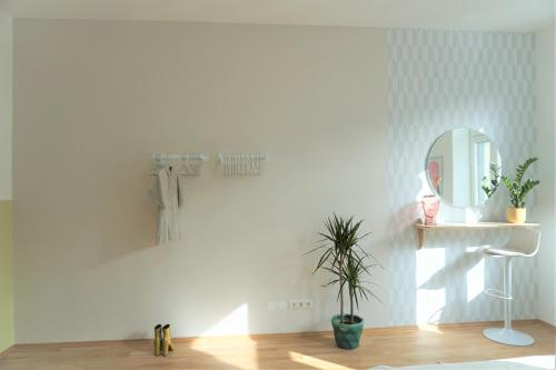 biały pokój z lustrem i rośliną w obiekcie Modern 2Br Apartments - Full Kitchen - Schönbrunn Area - 15 Mins to City Center w Wiedniu