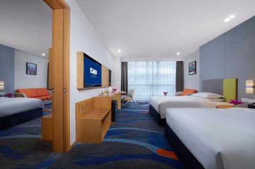 Habitación de hotel con camas y TV de pantalla plana. en Holiday Inn Express Zhengzhou Zhengdong, an IHG Hotel en Zhengzhou