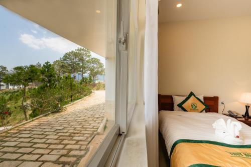 1 dormitorio con cama y vistas a la calle en Thuy Hoang Nguyen Resort & Spa, en Da Lat
