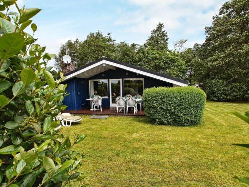 a blue shed with chairs and tables in a yard at 4 person holiday home in Hemmet in Hemmet