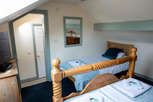 two twin beds in a room with a mirror at The Horse and Jockey in Tideswell