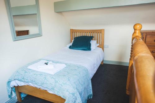 a bedroom with a bed with a blue pillow and a mirror at The Horse and Jockey in Tideswell