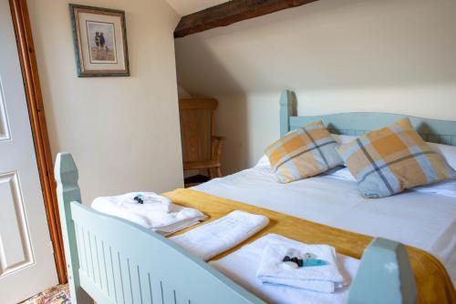 a bedroom with a bed with towels on it at The Horse and Jockey in Tideswell