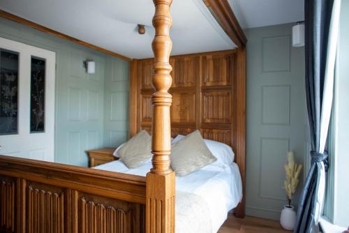 a bed with a wooden post in a bedroom at The Horse and Jockey in Tideswell