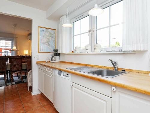 uma cozinha com um lavatório e uma bancada em 4 person holiday home in Bl vand em Blåvand