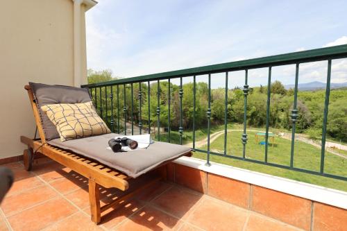 a cat laying on a bench on a balcony with a view at Studio Acropolis Serres With Parking Next to Center in Serres