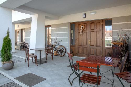 a patio with a wooden table and chairs at Csató Panzió - Pensiunea Csató in Joseni