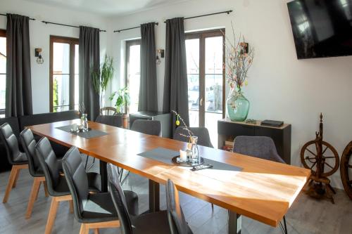 a dining room with a wooden table and chairs at Csató Panzió - Pensiunea Csató in Joseni