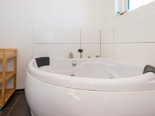 14 person holiday home in Glesborg في Glesborg: حوض استحمام أبيض في حمام أبيض