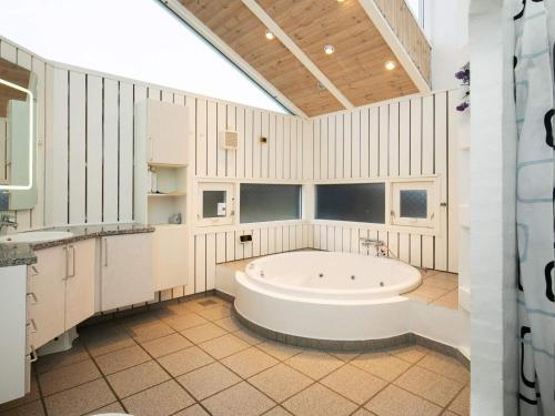 W dużej, białej łazience znajduje się wanna. w obiekcie Five-Bedroom Holiday home in Løkken 6 w mieście Grønhøj