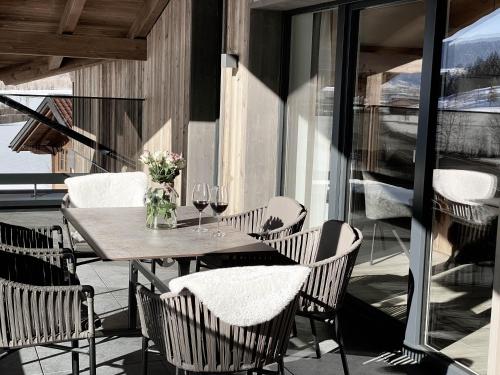 a table and chairs on a patio with wine glasses at Appartement Tauernblick Radstadt in Radstadt