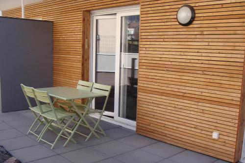 einen Tisch und Stühle auf einer Terrasse in der Unterkunft au bord du lac in Gérardmer